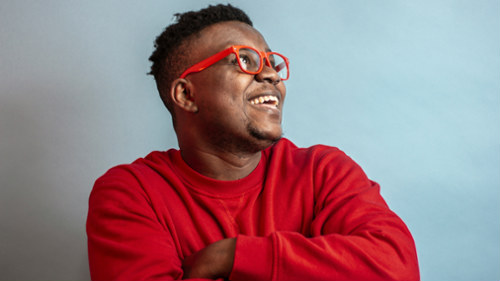 Smiling man wearing red glasses featured in Sutton Dentistry blog about common dental questions peop