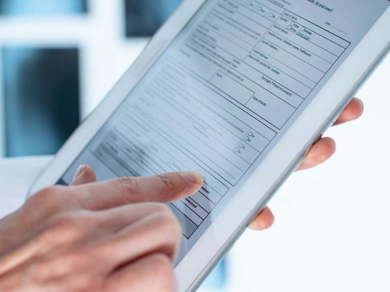 Patient completing digital dental forms on a tablet for a streamlined check-in experience at Sutton Dentistry in Ocala, FL.
